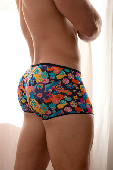 Colorful patterned underwear worn by a person against a neutral background
